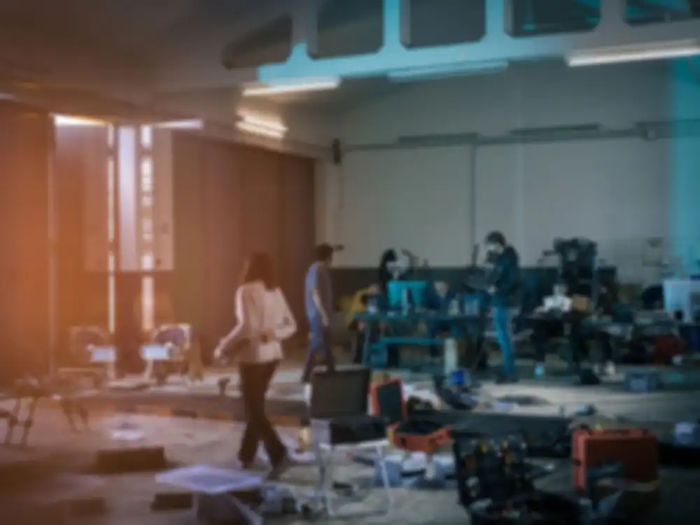 Personen arbeiten in einer Halle an den Dronen und esstehen dort viele technische Geräte